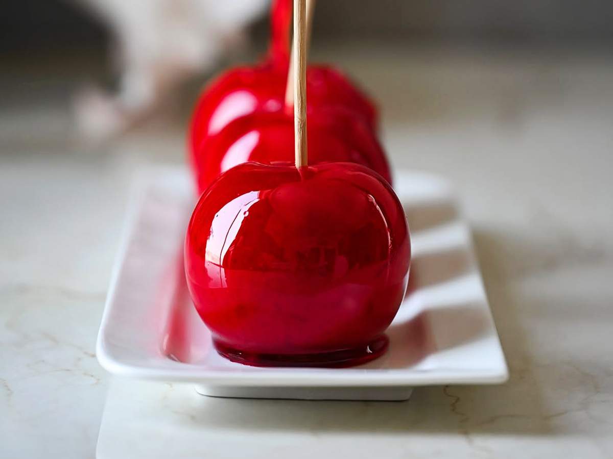 Maçã do amor coberta com caramelo vermelho brilhante.